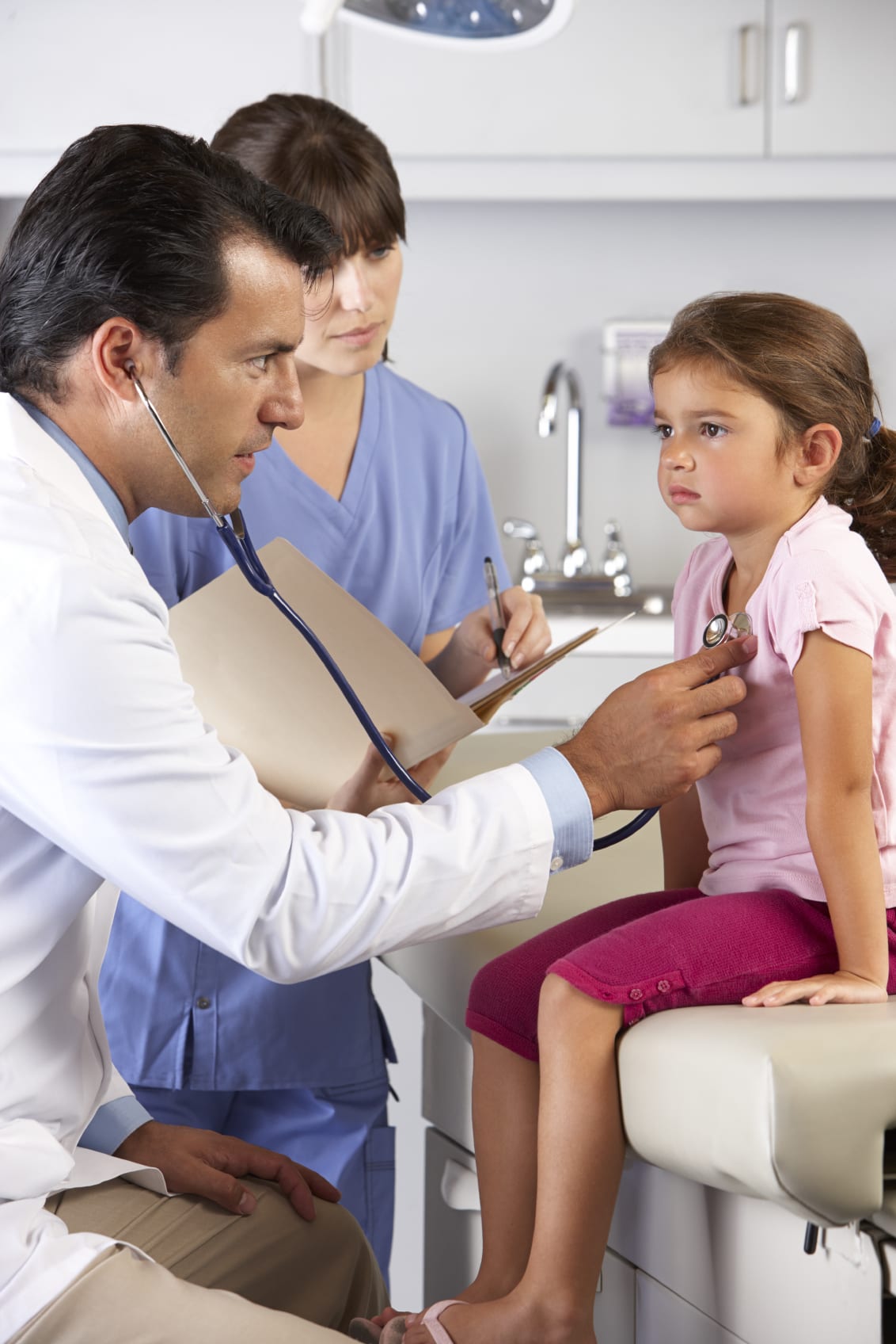 child in medical office having heartbeat examined