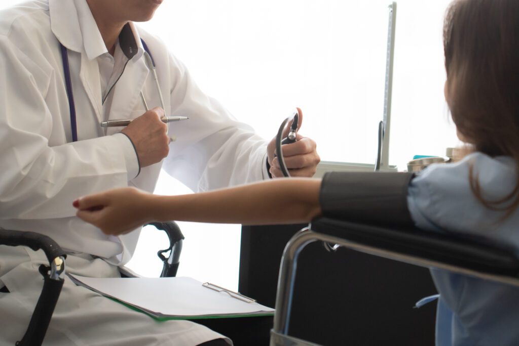 Doctor Checking Blood Pressure Of Patient At Medical Clinic